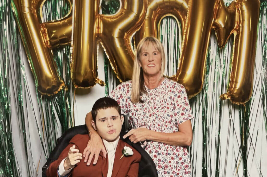 Teenage boy sitting down with mum at his prom
